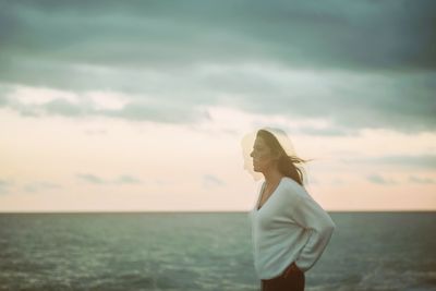 Burred motion of woman at beach against sky