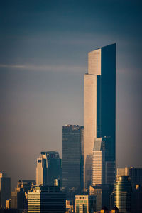 Modern buildings in city against sky during sunset