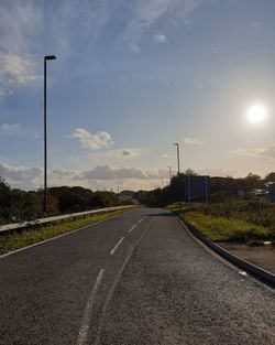 Empty road by street against sky