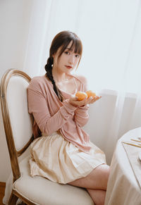 Portrait of young woman sitting on sofa at home