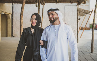 Smiling couple walking on street in town