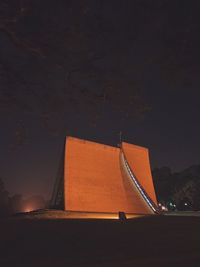 Low angle view of illuminated building against sky at night