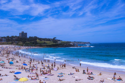 People on beach against blue sky