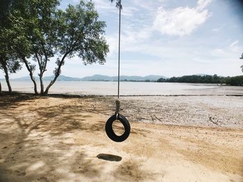 Bicycle on swing against sky