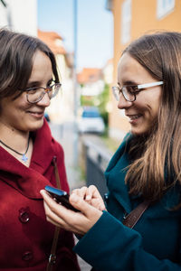 Smiling young woman using mobile phone