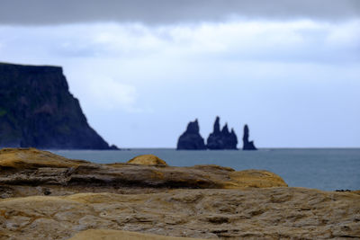 Scenic view of sea and mountains against sky