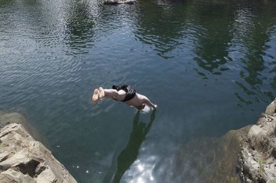 Reflection of man swimming in lake