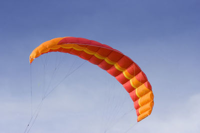 Low angle view of person paragliding against sky