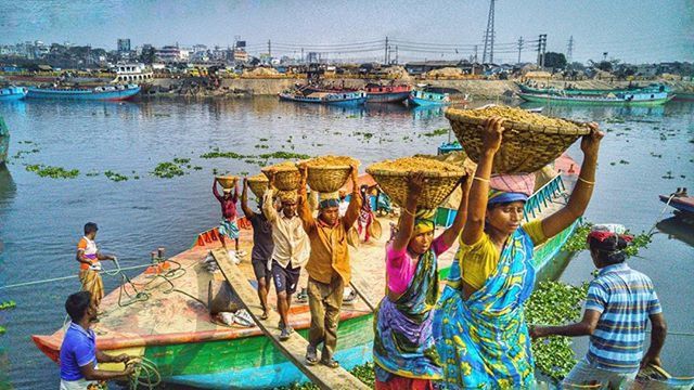 water, nautical vessel, boat, lifestyles, transportation, leisure activity, men, moored, mode of transport, sea, person, blue, sitting, vacations, lake, rear view, sky, large group of people, togetherness