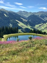 Scenic view of lake by mountains against sky