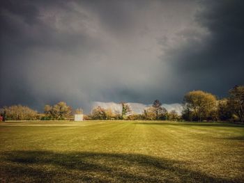 Scenic view of grassy field against cloudy sky