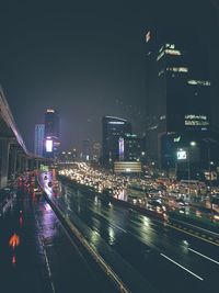 Illuminated buildings in city against sky at night