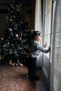 Woman standing by christmas tree