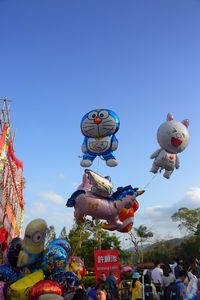 Low angle view of multi colored umbrellas against clear blue sky