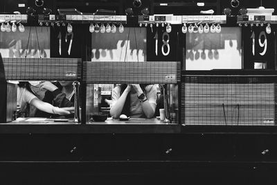 Midsection of people sitting in restaurant seen through windows