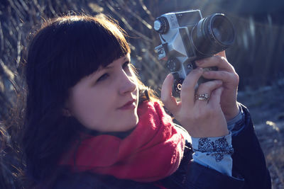 Close-up of young woman photographing with camera