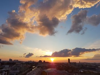 Buildings in city against sky during sunset