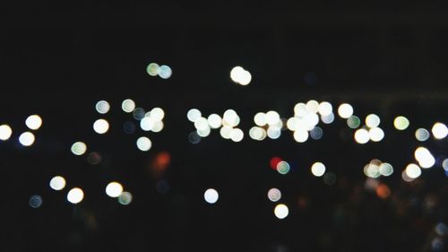 Low angle view of illuminated lights against sky at night