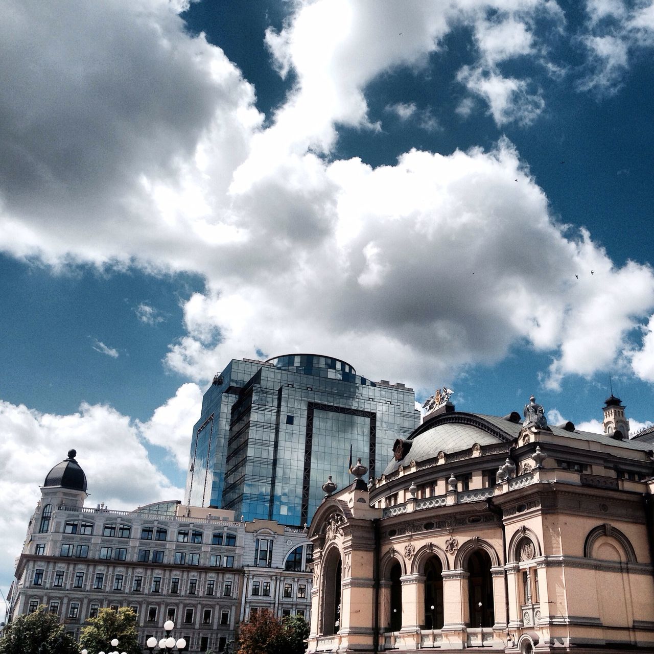 architecture, building exterior, built structure, low angle view, sky, cloud - sky, cloud, city, cloudy, building, window, high section, arch, outdoors, day, history, no people, facade, travel destinations, sunlight