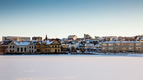 Houses in town against clear sky during winter