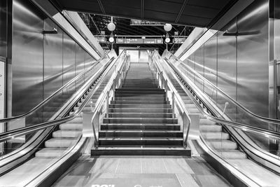 Rear view of man walking on escalator