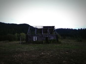 Abandoned house on field against clear sky