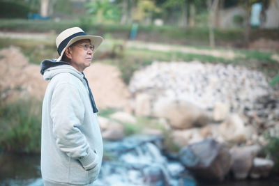 Side view of man standing by plants