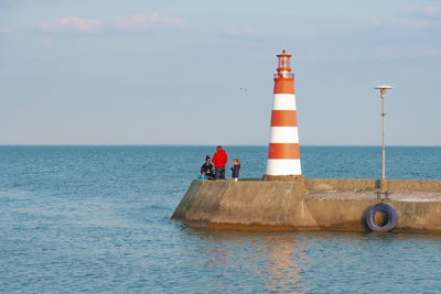 Lighthouse on sea against sky