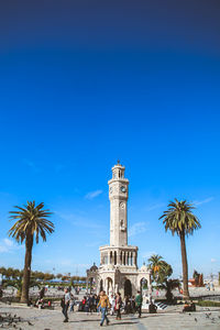 Low angle view of palm trees against clear blue sky