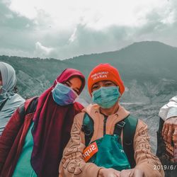 High angle portrait of woman on mountain against sky