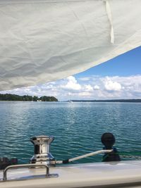 Rear view of boat sailing in sea against sky