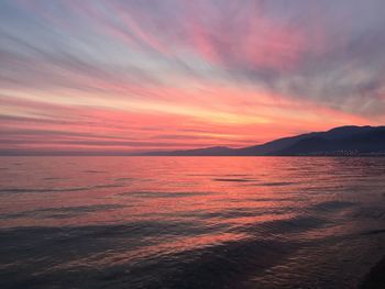 Scenic view of sea against dramatic sky during sunset