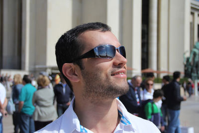 Portrait of young man wearing sunglasses with eiffel tower reflected in his glasses.