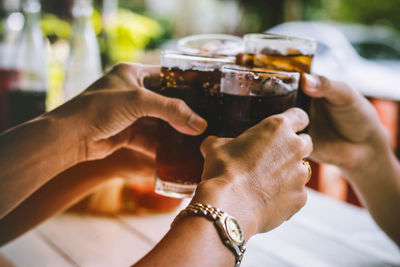 Cropped hands toasting drinks