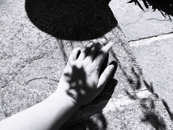 High angle view of person touching shadow on hand