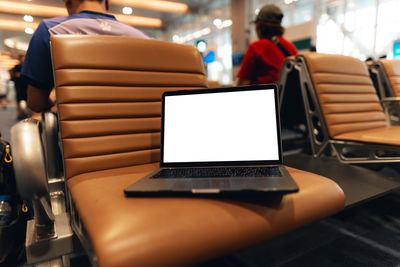 Midsection of woman using laptop at cafe