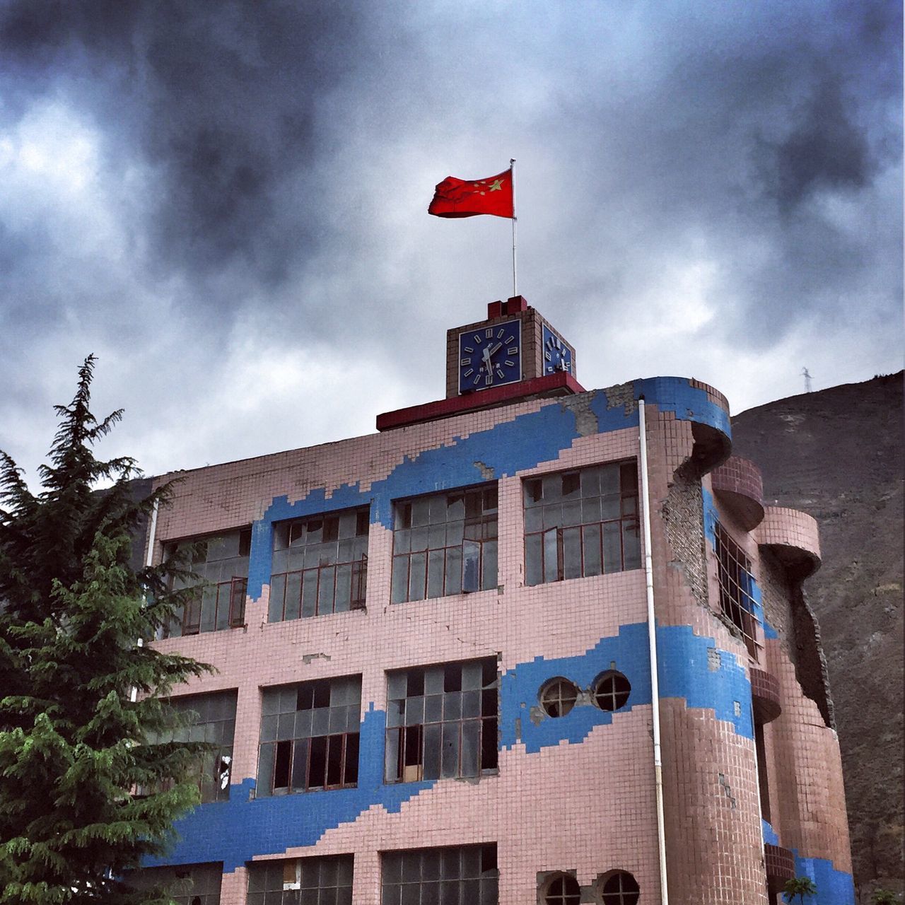 building exterior, architecture, built structure, sky, low angle view, flag, cloud - sky, patriotism, national flag, identity, american flag, cloud, cloudy, tower, city, day, building, outdoors, no people, red