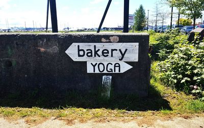 Close-up of road sign against sky