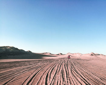 Scenic view of desert against clear blue sky