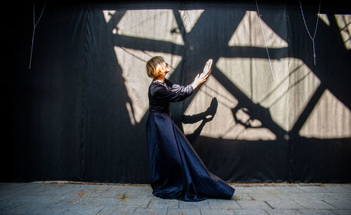 Rear view of woman standing against wall