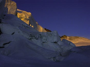 Scenic view of snowcapped mountains against clear blue sky