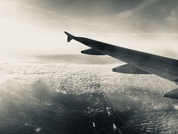 Close-up of airplane wing against sky