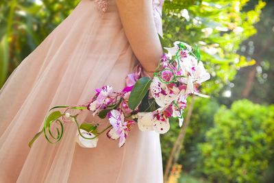 Midsection of woman with pink flower