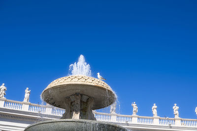 Low angle view of statue against blue sky