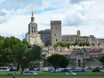 Buildings in city against cloudy sky