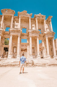 Full length rear view of man standing in front of historical building