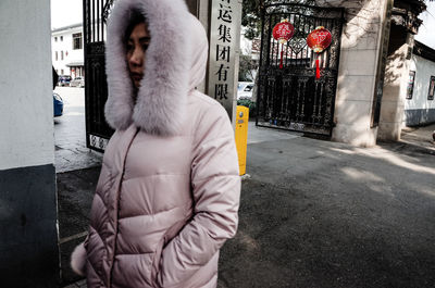 Midsection of woman standing on street in city during winter