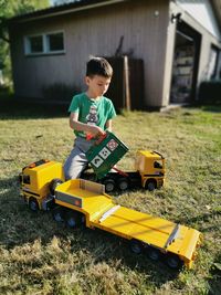Boy playing with toy cars at yard