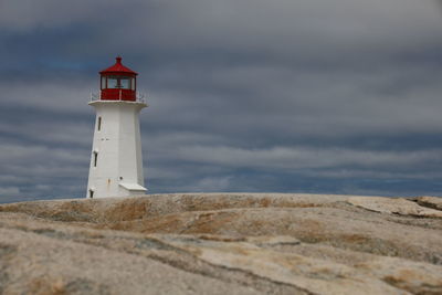 Lighthouse by sea against sky