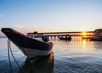 Boats in river at sunset